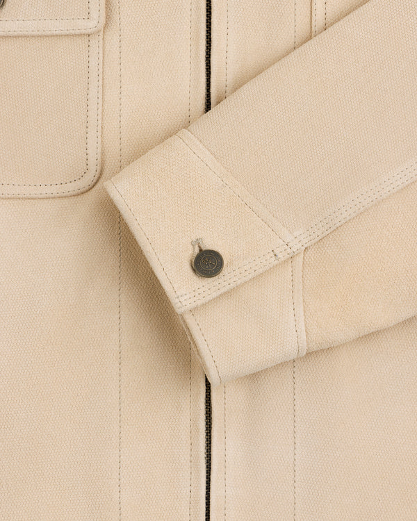 Close-up of the Leather Ranch Jacket shows a beige textured sleeve cuff with button and part of the chest pocket.