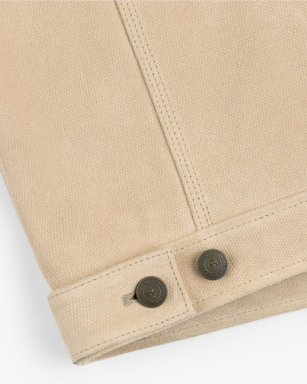Close-up of a Leather Ranch Jacket sleeve in beige textured fabric with two metallic cuff buttons and visible stitching.