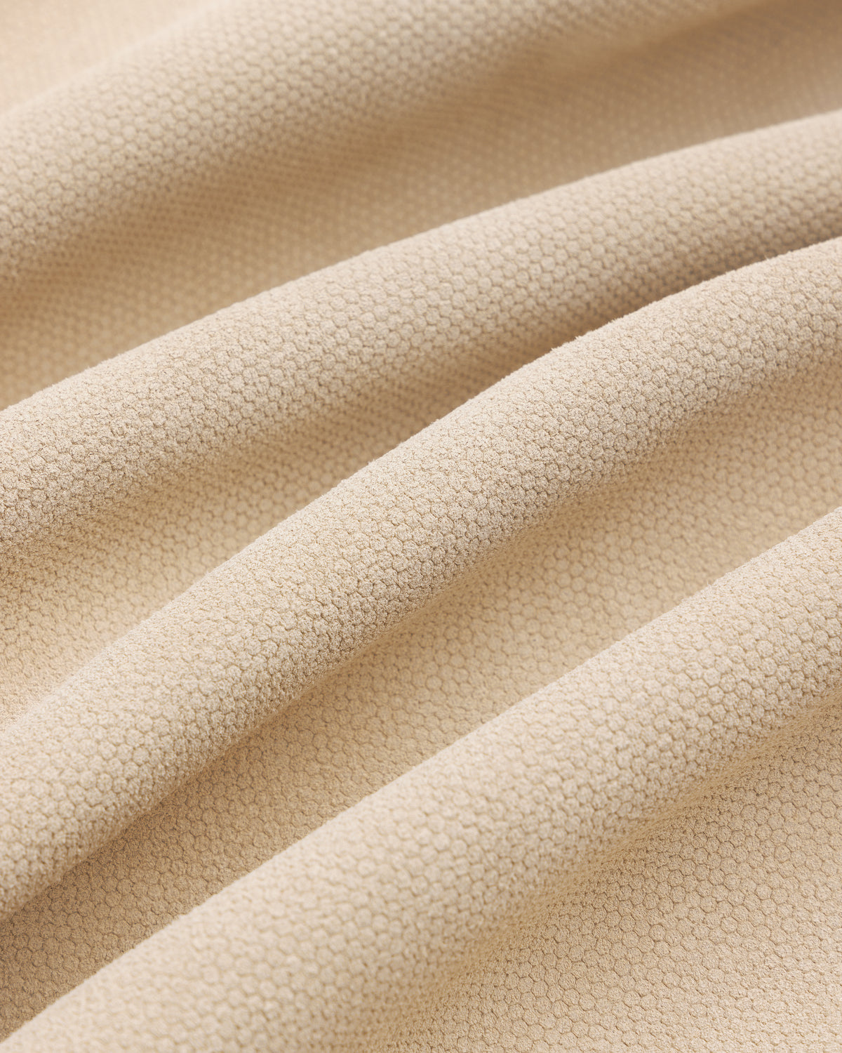 Close-up of beige textured Leather Ranch Jacket with small hexagonal patterns and soft, wavy folds.