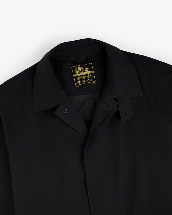 Black-collared GORE-TEX Balmacaan Coat with a visible yellow and black label on the inner neck.