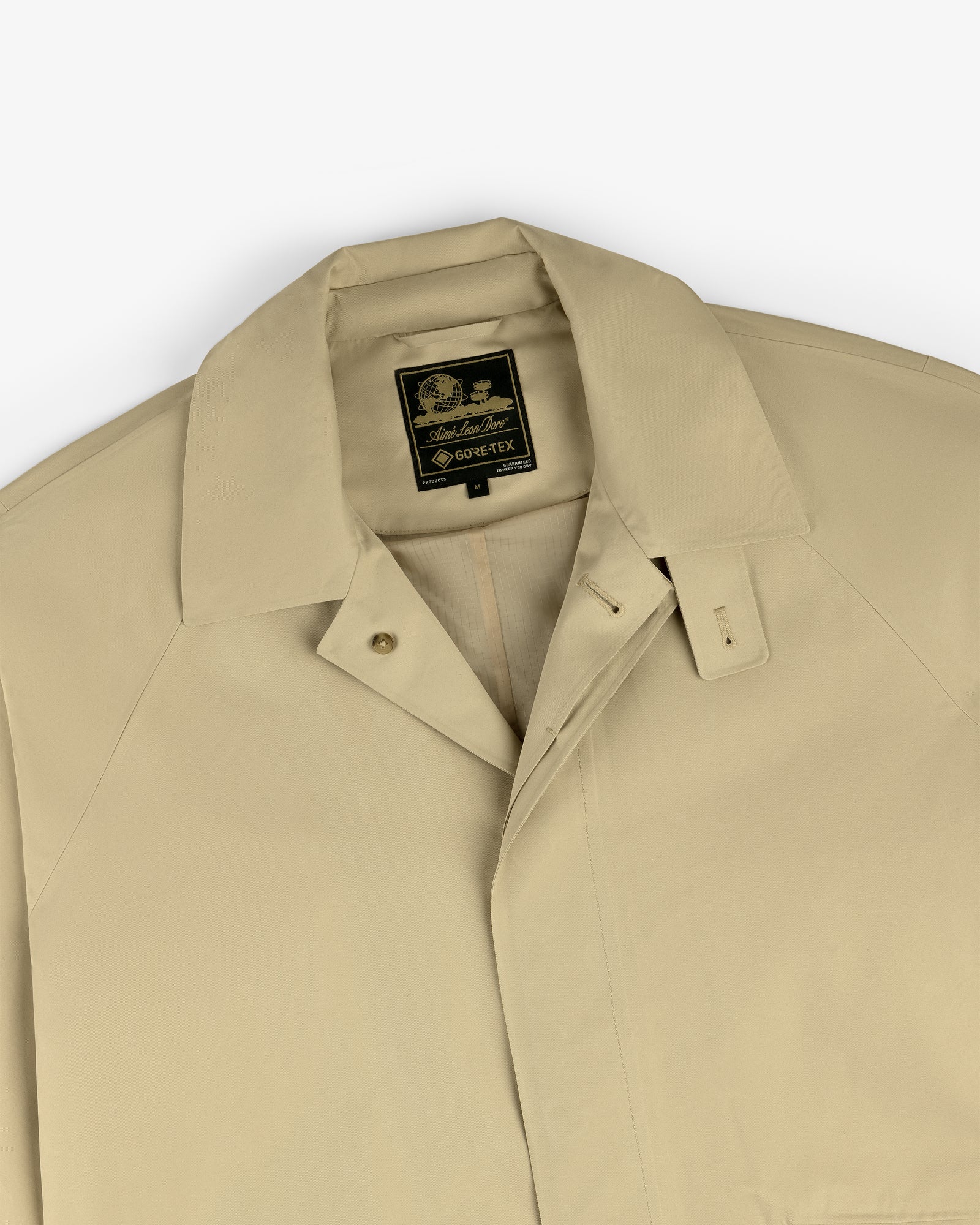 Beige GORE-TEX Balmacaan Coat with a pointed collar and a black and gold Sanders & Sanders label.