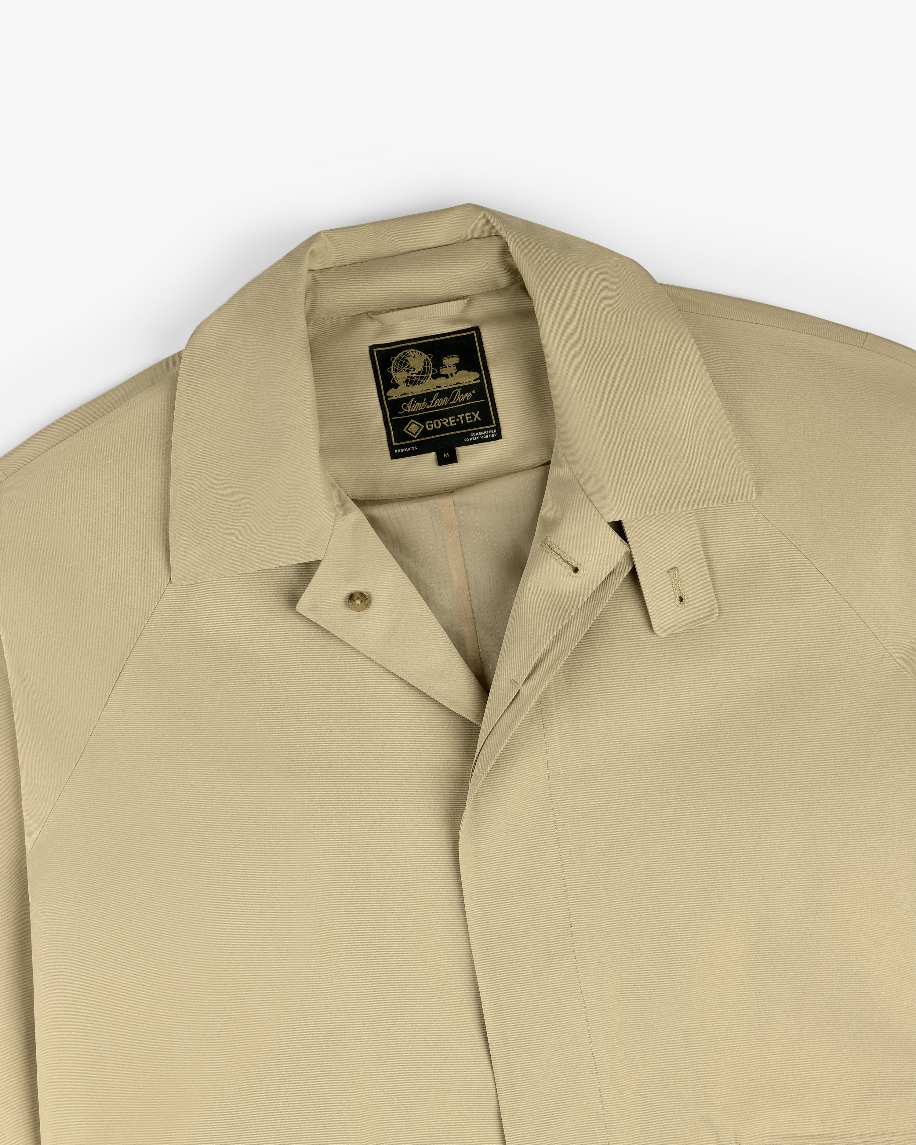 Beige GORE-TEX Balmacaan Coat with a pointed collar and a black and gold Sanders & Sanders label.