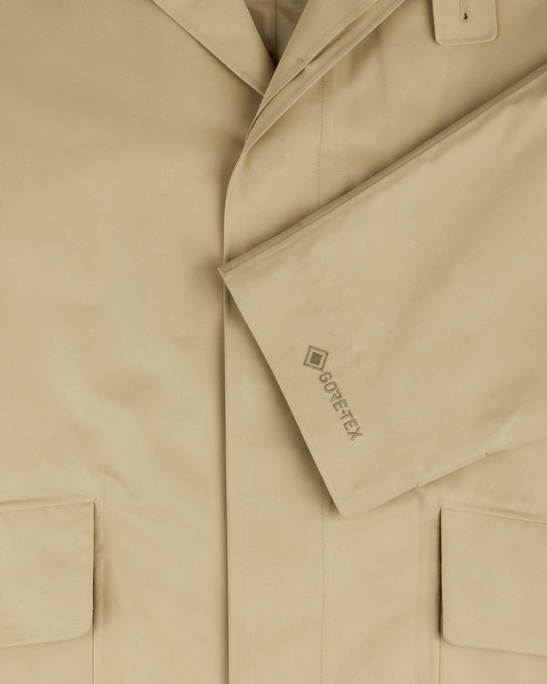 Close-up of the GORE-TEX Balmacaan Coat in beige, featuring large pockets and GORE-TEX embroidered on the sleeve.