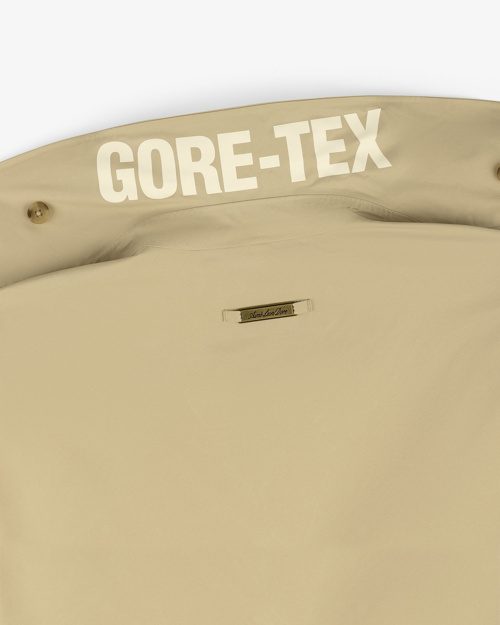 Close-up of the GORE-TEX Balmacaan Coat's beige collar with bold white GORE-TEX text inside.