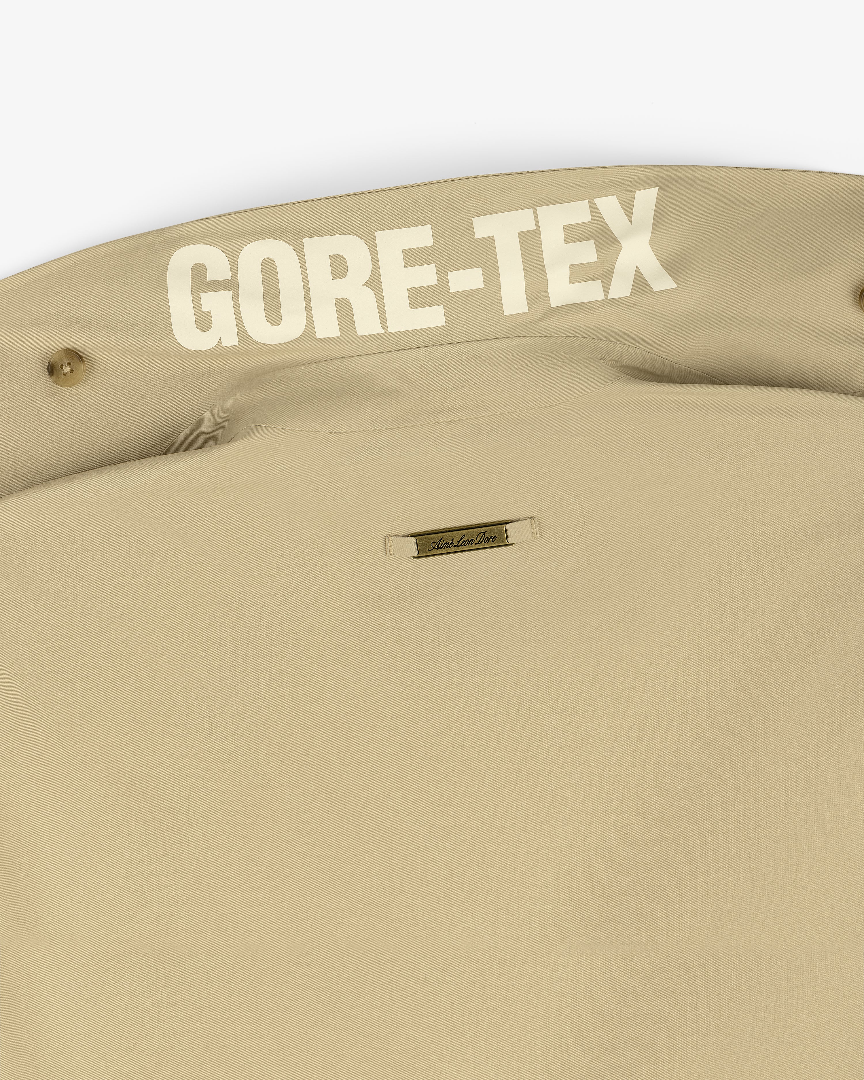 Close-up of the GORE-TEX Balmacaan Coat's beige collar with bold white GORE-TEX text inside.