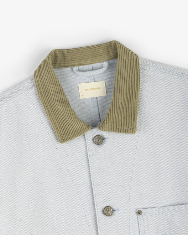 The Denim Barn Jacket features light denim, a ribbed olive green collar, two buttons, and a chest pocket.