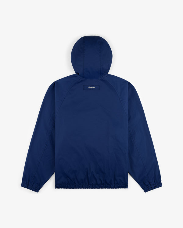 Reversible Madras Windbreaker in navy blue, shown from the back with elastic cuffs and hem on a plain white background.