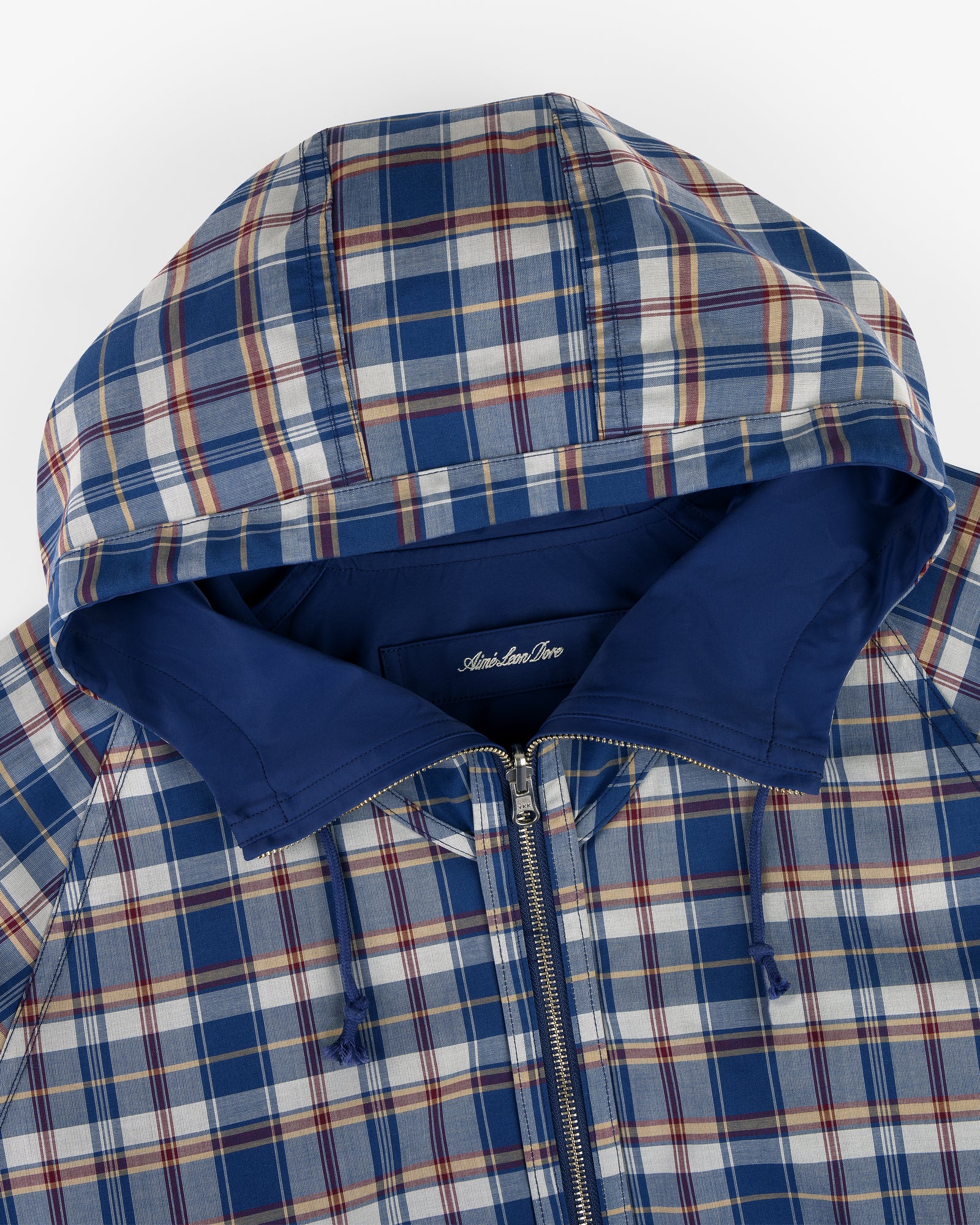 Reversible Madras Windbreaker in blue and white plaid with a zip front and solid blue hood lining.