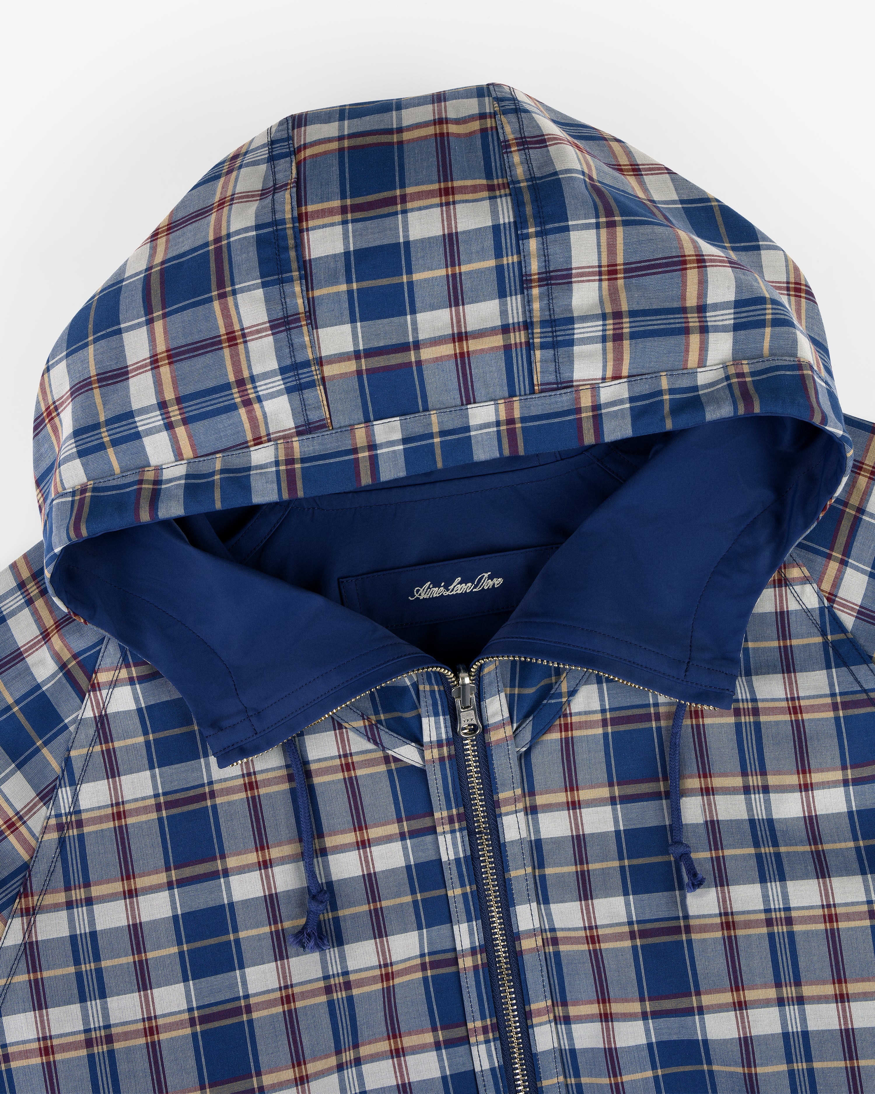Reversible Madras Windbreaker in blue and white plaid with a zip front and solid blue hood lining.