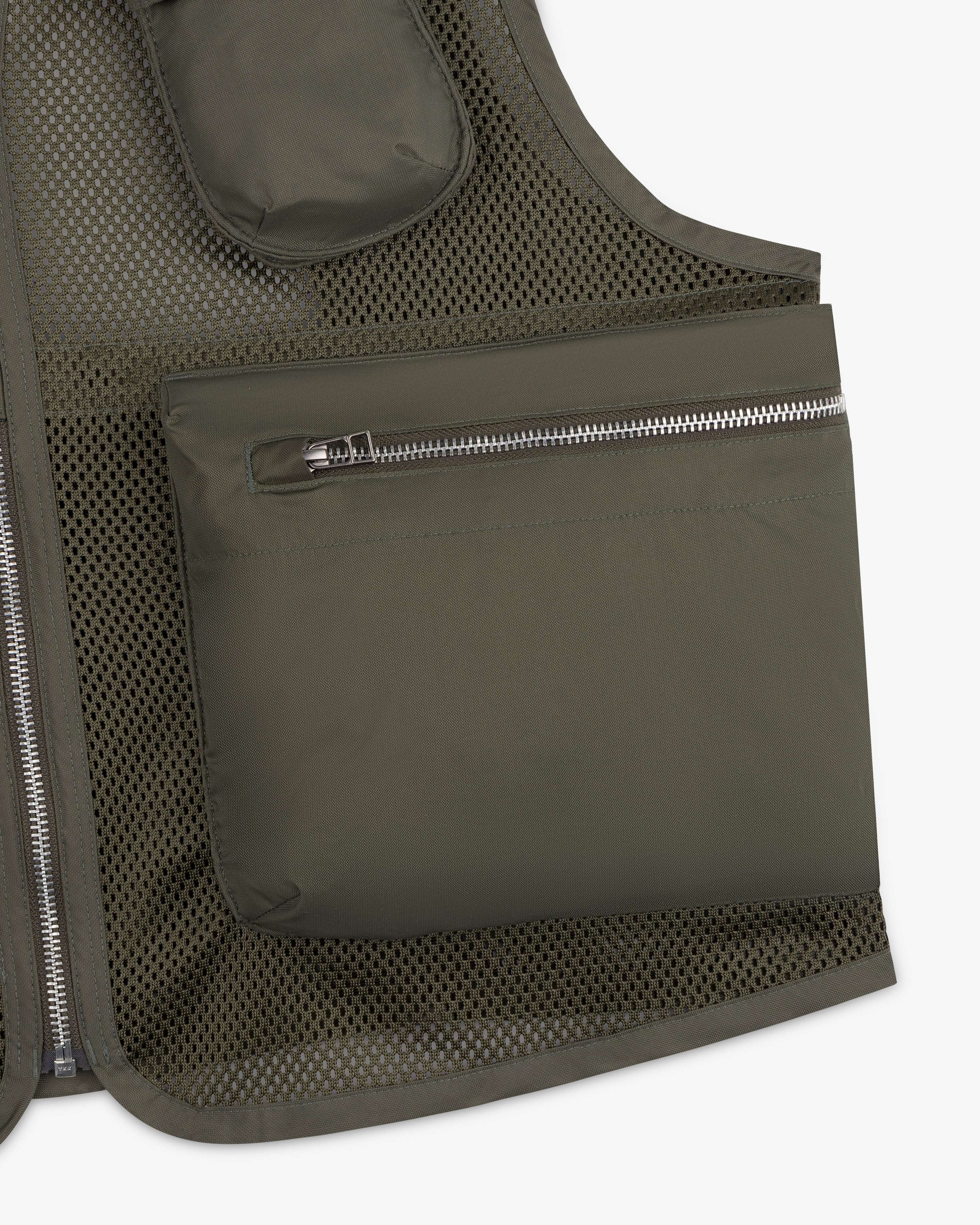 Close-up of the Nylon Utility Vest in olive green mesh, featuring a large zippered pocket and visible stitching.