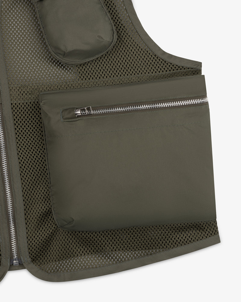 Close-up of the Nylon Utility Vest in olive green mesh, featuring a large zippered pocket and visible stitching.
