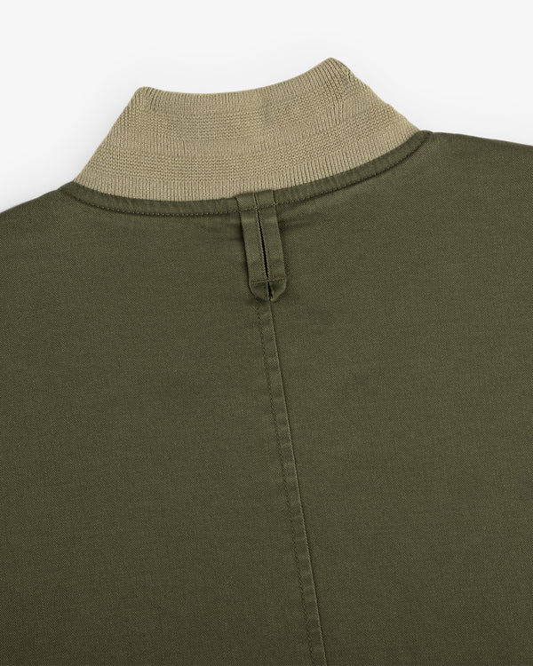 Close-up of the Safari Utility Bomber in olive green with a beige ribbed collar, back seam, and fabric loop.