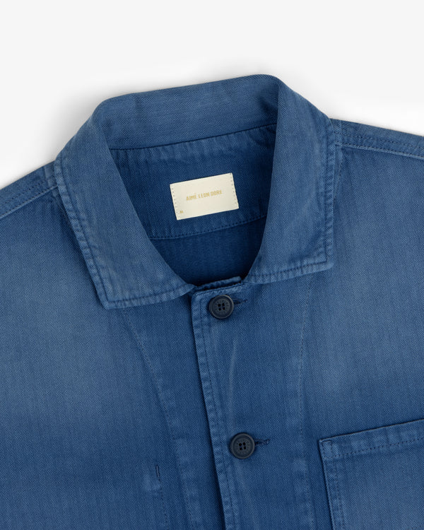 Sun Faded Chore Jacket in blue denim with collar, black buttons, and chest pocket on a white background.
