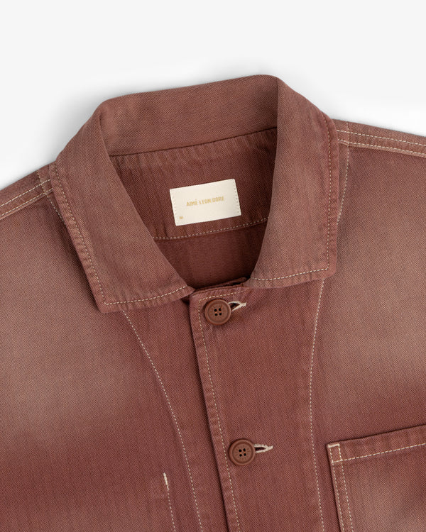 Sun Faded Chore Jacket in reddish-brown with visible stitching, two buttons, and a label inside the collar.
