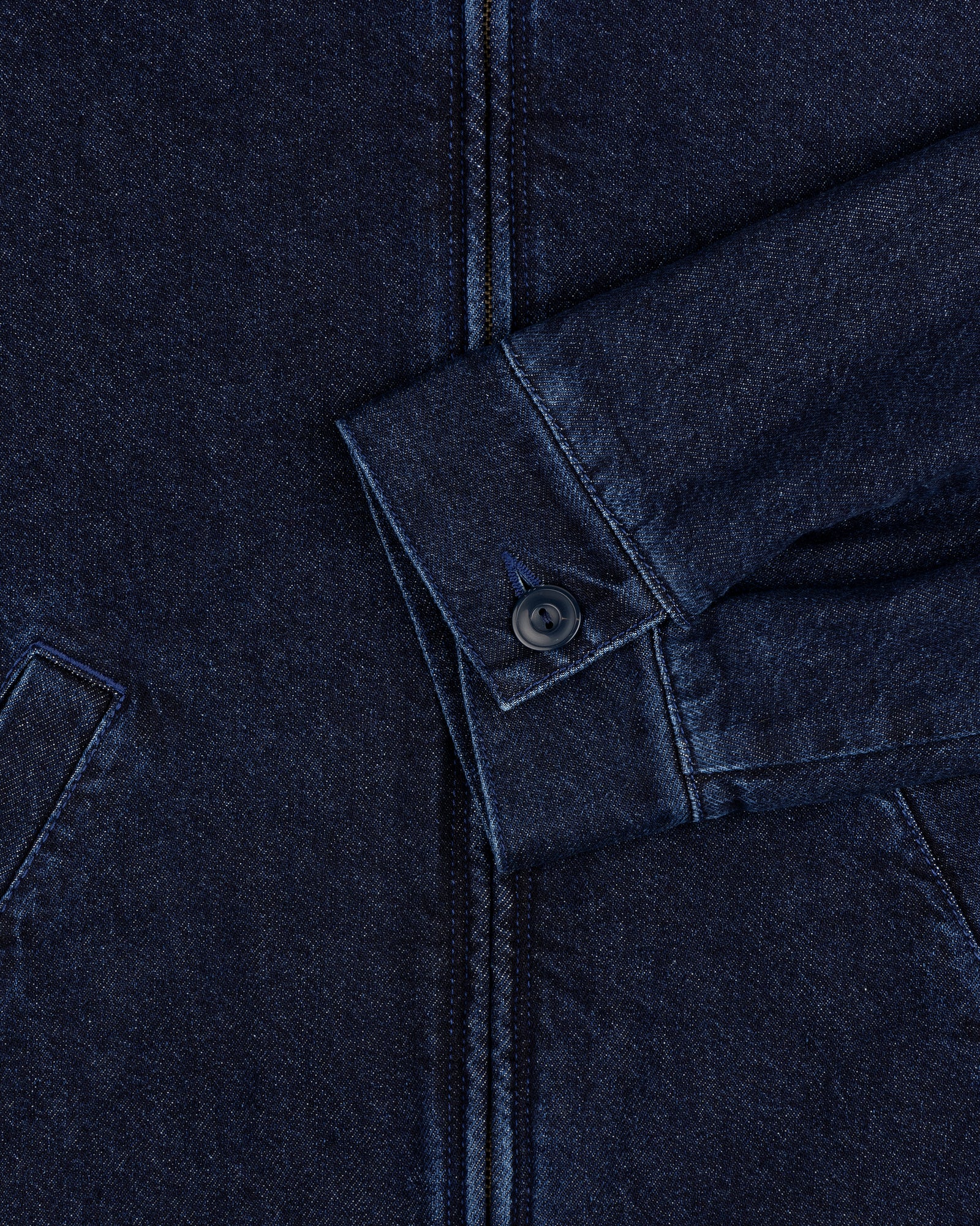 Close-up of Denim Zip Jacket sleeve in dark blue with visible buttoned cuff and partial front pockets.
