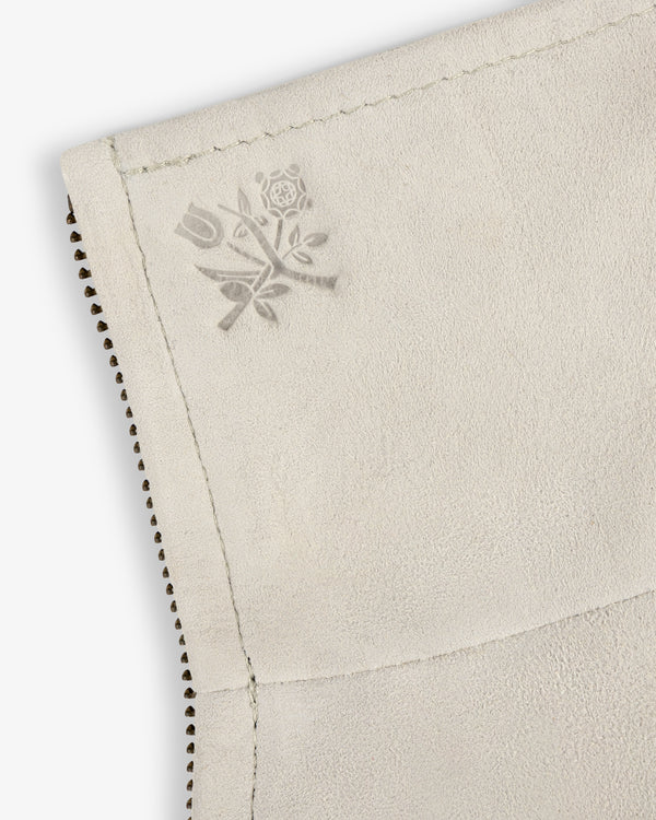 Close-up of light suede fabric on Suede Track Jacket, featuring stitched edges and an embossed rose-tulip floral design.
