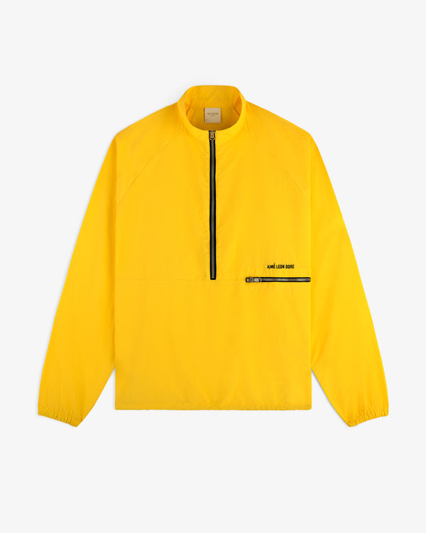 Bright yellow Nylon Packable Windbreaker with black half-zip, zip chest pocket, and AIMÉ LEON DORE branding.