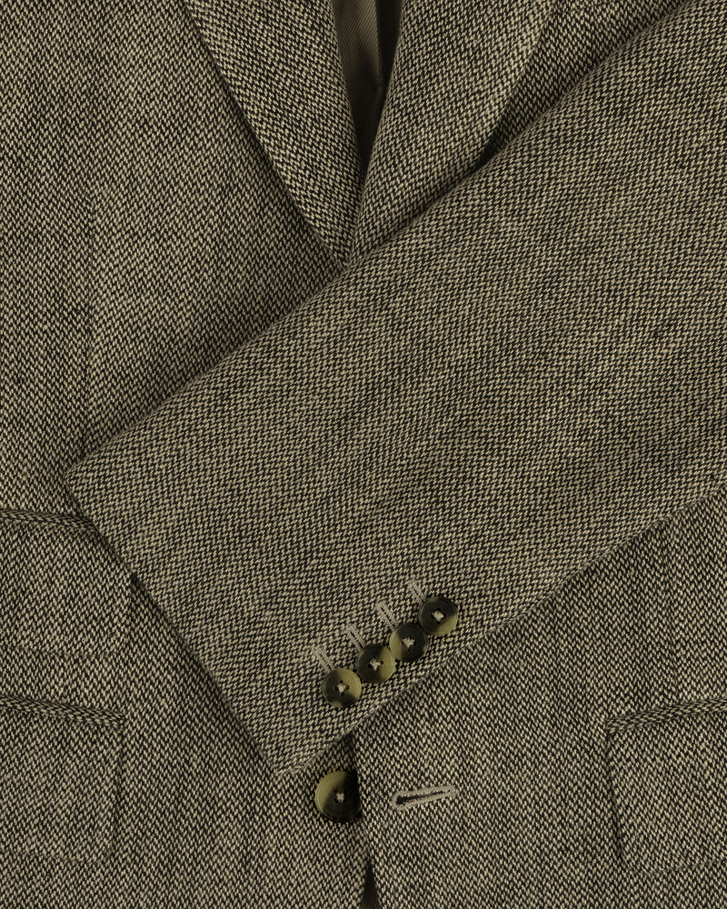 Close-up of a Single-Breasted Yarn Dyed Linen Suit Jacket sleeve with four dark buttons and textured fabric.