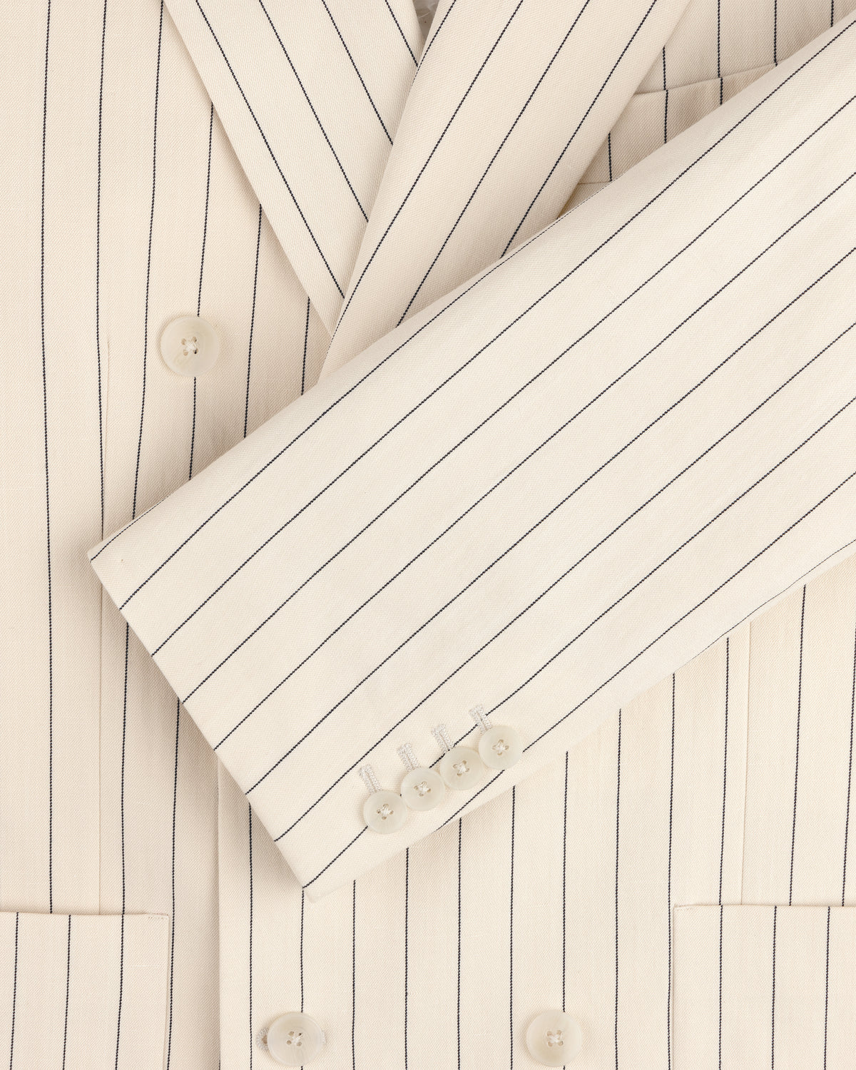 Close-up of a cream Double-Breasted Pinstripe Suit Jacket featuring buttons on the sleeve and front.