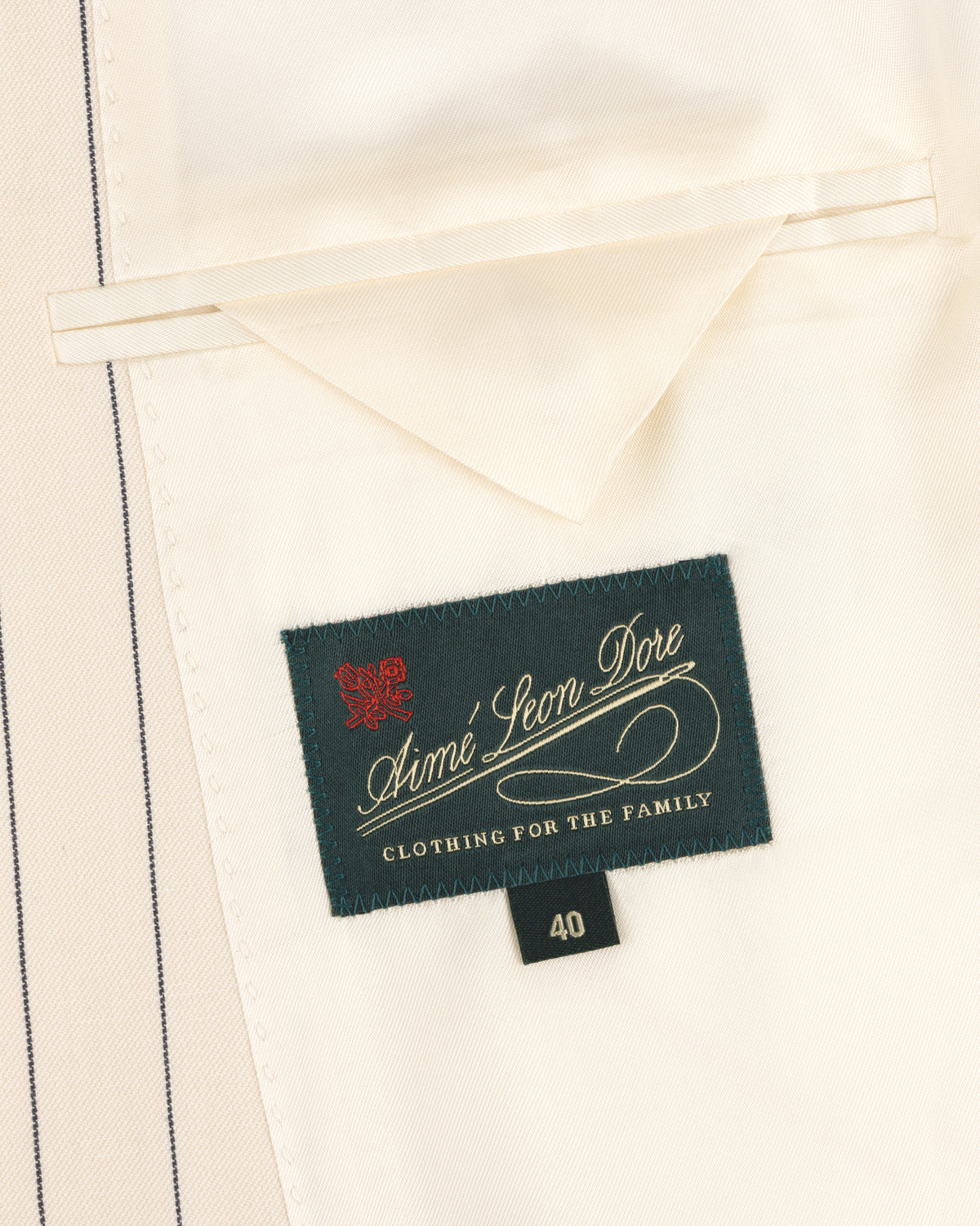 A cream lining with an Aimé Leon Dore label and size 40 tag inside the Double-Breasted Pinstripe Suit Jacket.