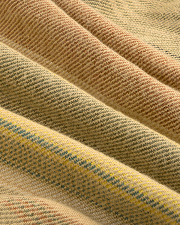 Close-up of folded Blanket Striped Chore Jacket with textured yellow and brown wool and subtle diagonal stripes.