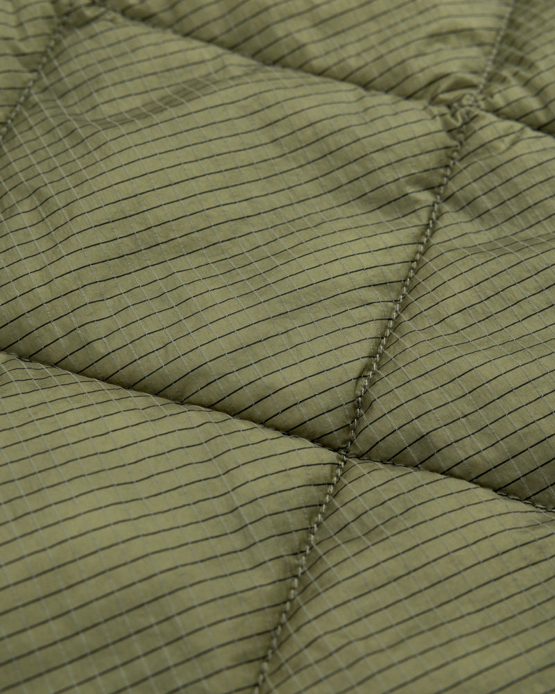 Close-up of the Nylon Quilted Unisphere Jacket in olive green, showing its grid pattern and visible stitching.