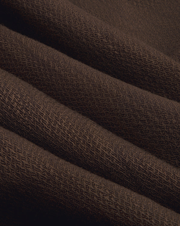 Close-up of folded, textured brown Single-Breasted Linen Blend Suit Jacket showing knit pattern and soft ridges.