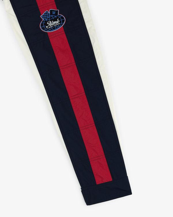 Nylon Moto Jacket featuring vertical red and navy stripes and a blue embroidered patch near the hip.