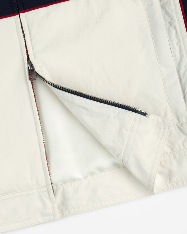 Close-up of a partially unzipped Nylon Moto Jacket in cream with visible zipper and stitching details.