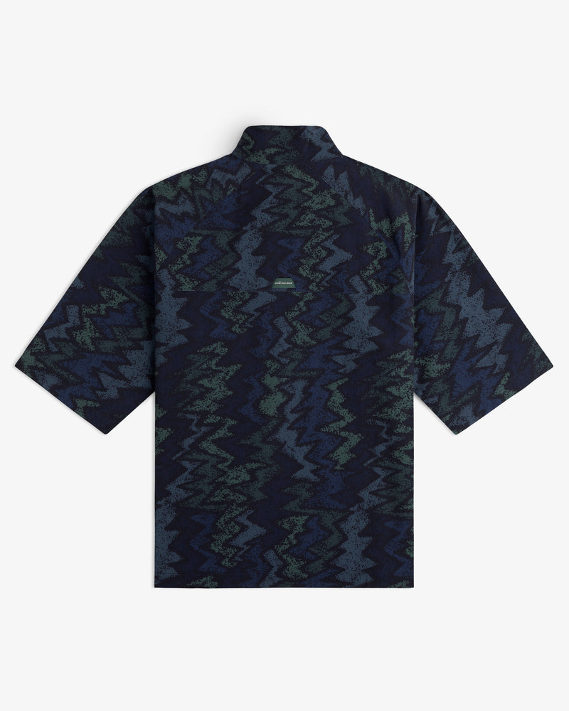 The ALD Golf Nylon Quarter Zip Pullover, shown flat from the back, features a navy, green, and gray zigzag pattern.
