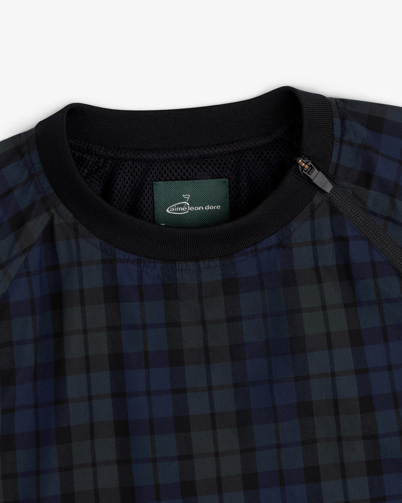 Close-up of the ALD Golf Blackwatch Pullover featuring navy and black plaid, a black collar, and a zip at the neckline.