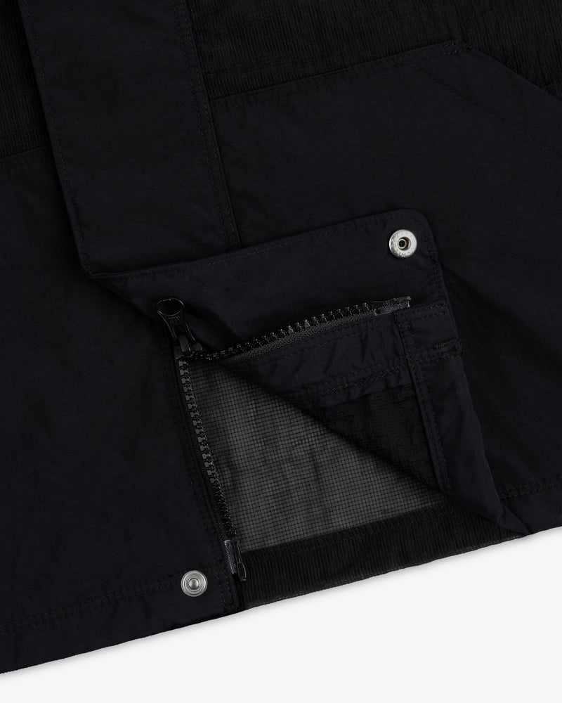 Close-up of the Nylon Track Jacket featuring an open zippered pocket and metal snap button details.