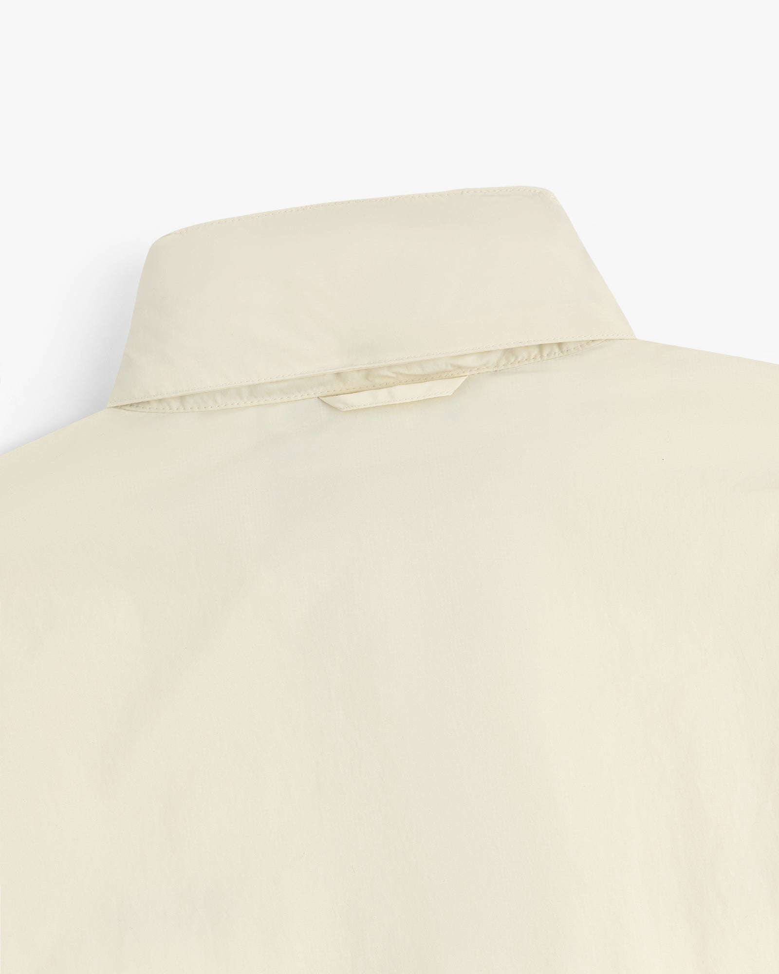 Close-up of the back of a beige Nylon Track Jacket, highlighting the collar and upper back details.
