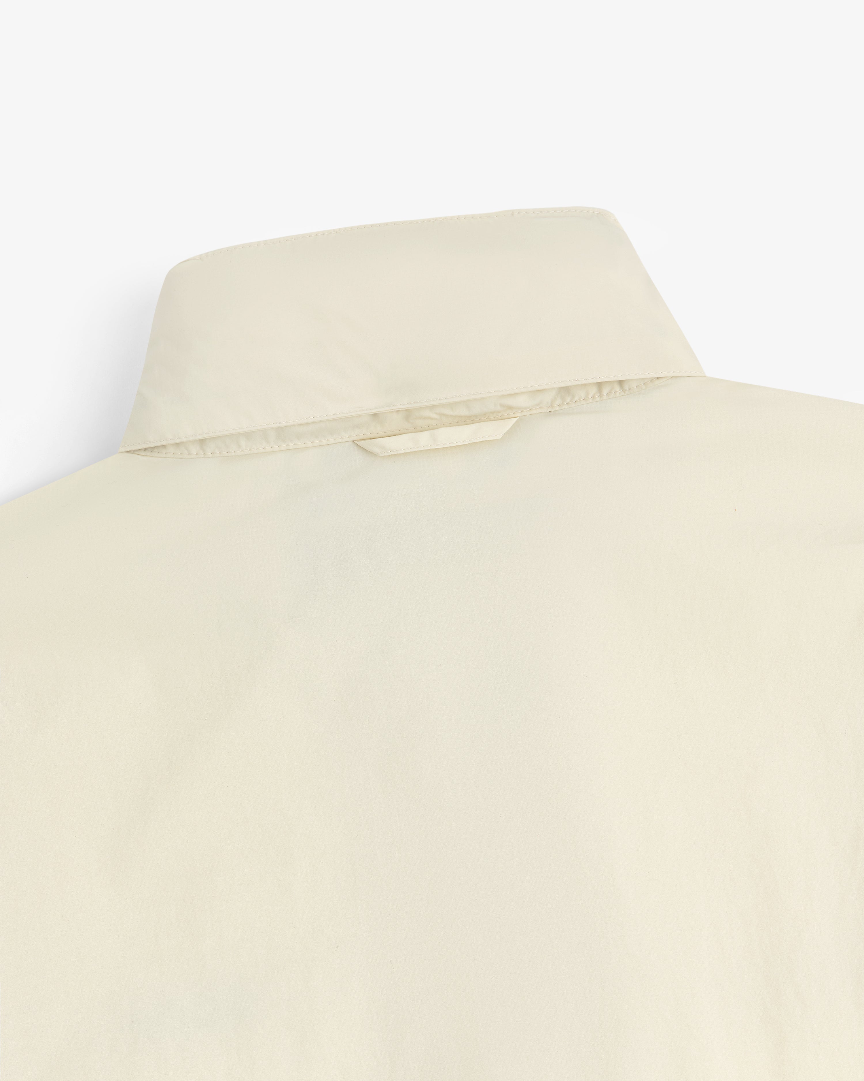 Close-up of the back of a beige Nylon Track Jacket, highlighting the collar and upper back details.