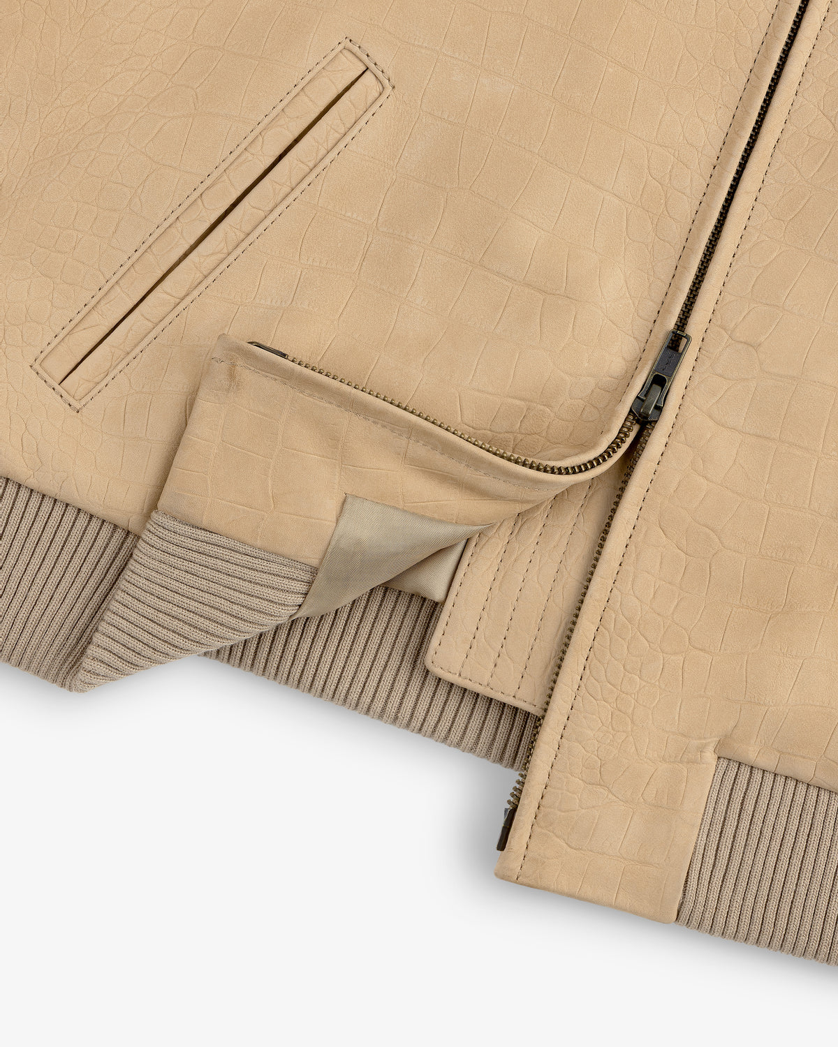 Close-up of the Croc-Embossed Nubuck Bomber Jacket, tan with zipper, pocket, and inner lining partially visible.