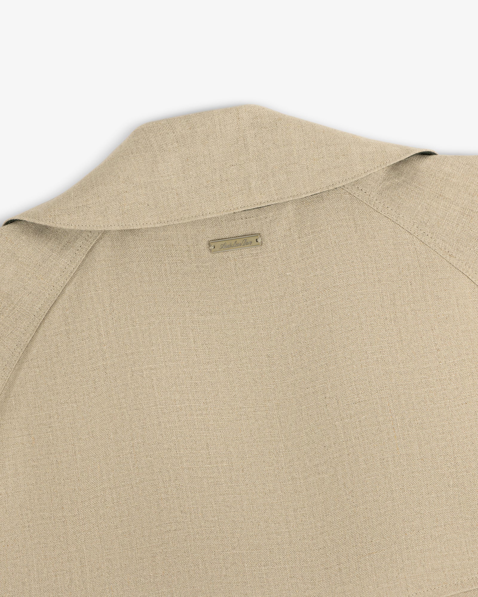 Close-up of the back and collar of the Linen Trench Coat, featuring a small rectangular label at the neck.