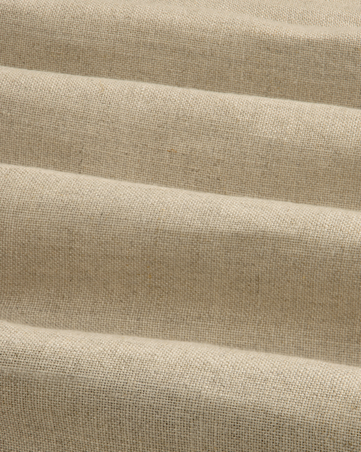 Close-up of beige Linen Trench Coat fabric, showing textured weave and soft, horizontal folds.