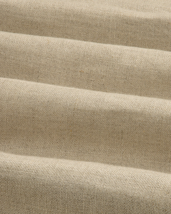 Close-up of beige Linen Trench Coat fabric, showing textured weave and soft, horizontal folds.