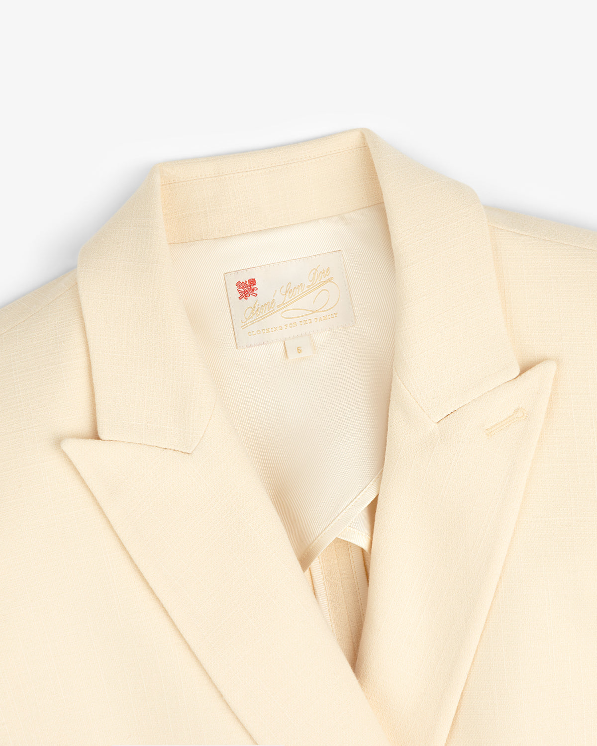 Cream-colored Double-Breasted Unconstructed Blazer with a notched lapel and label inside the collar.