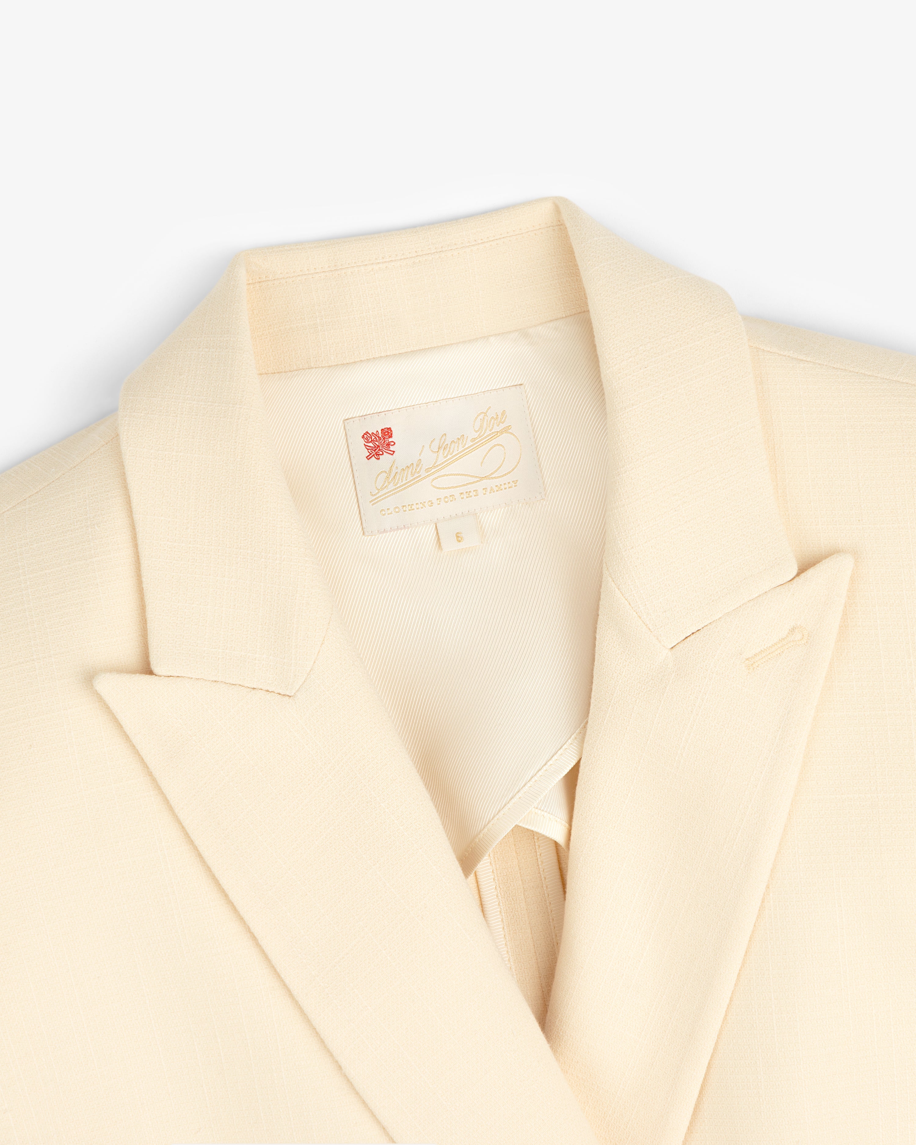 Cream-colored Double-Breasted Unconstructed Blazer with a notched lapel and label inside the collar.