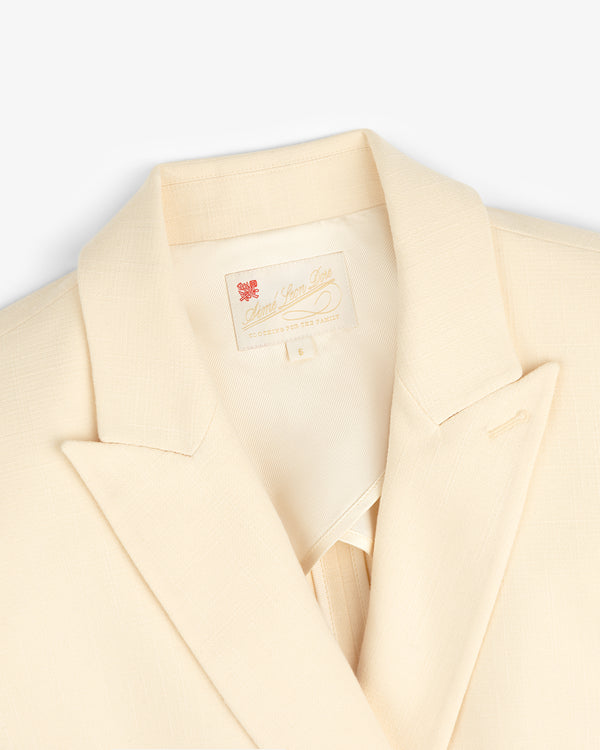 Cream-colored Double-Breasted Unconstructed Blazer with a notched lapel and label inside the collar.