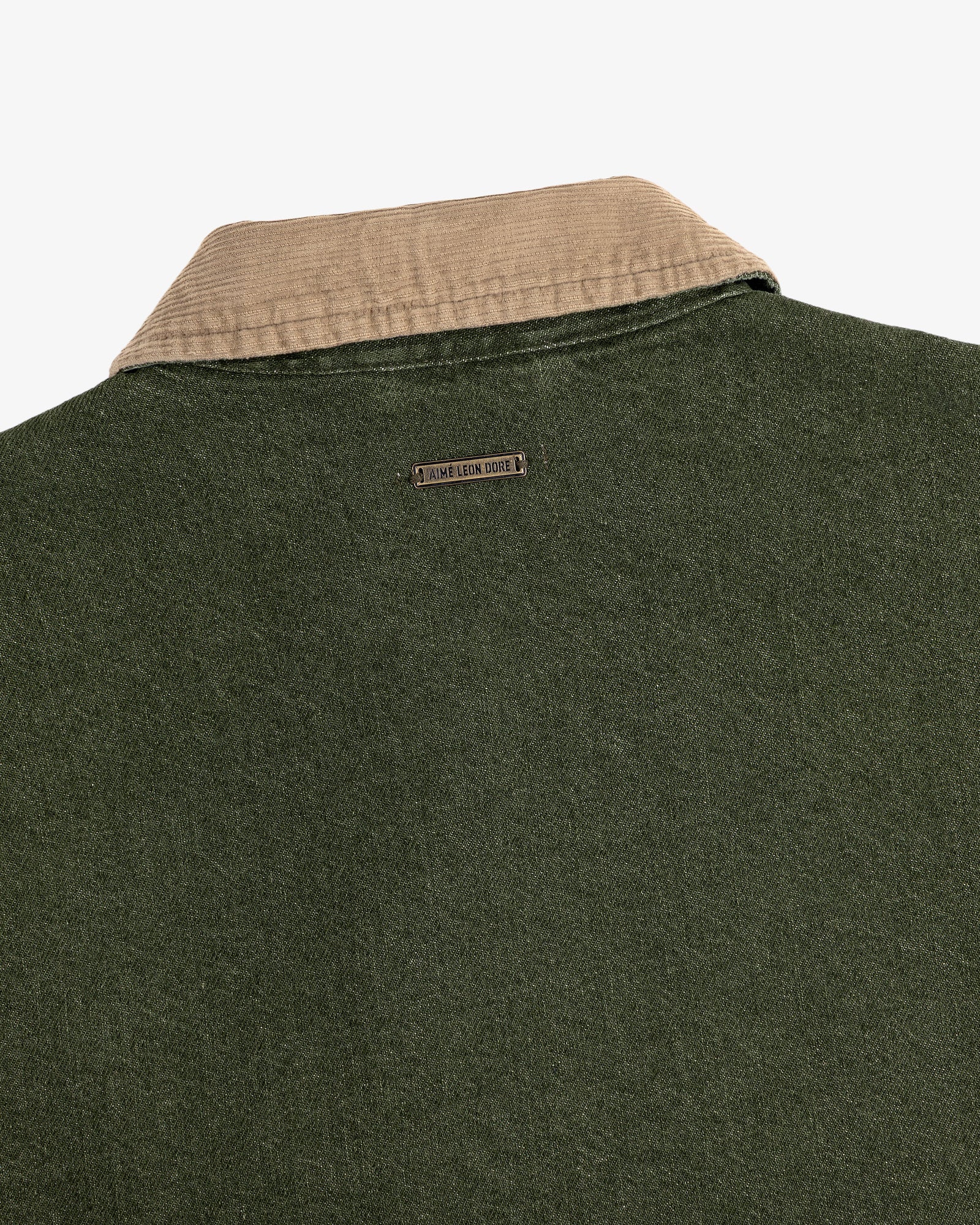 Close-up of the back of a green Denim Zip Jacket with a beige collar and a small metal Jamie Leake logo tag.