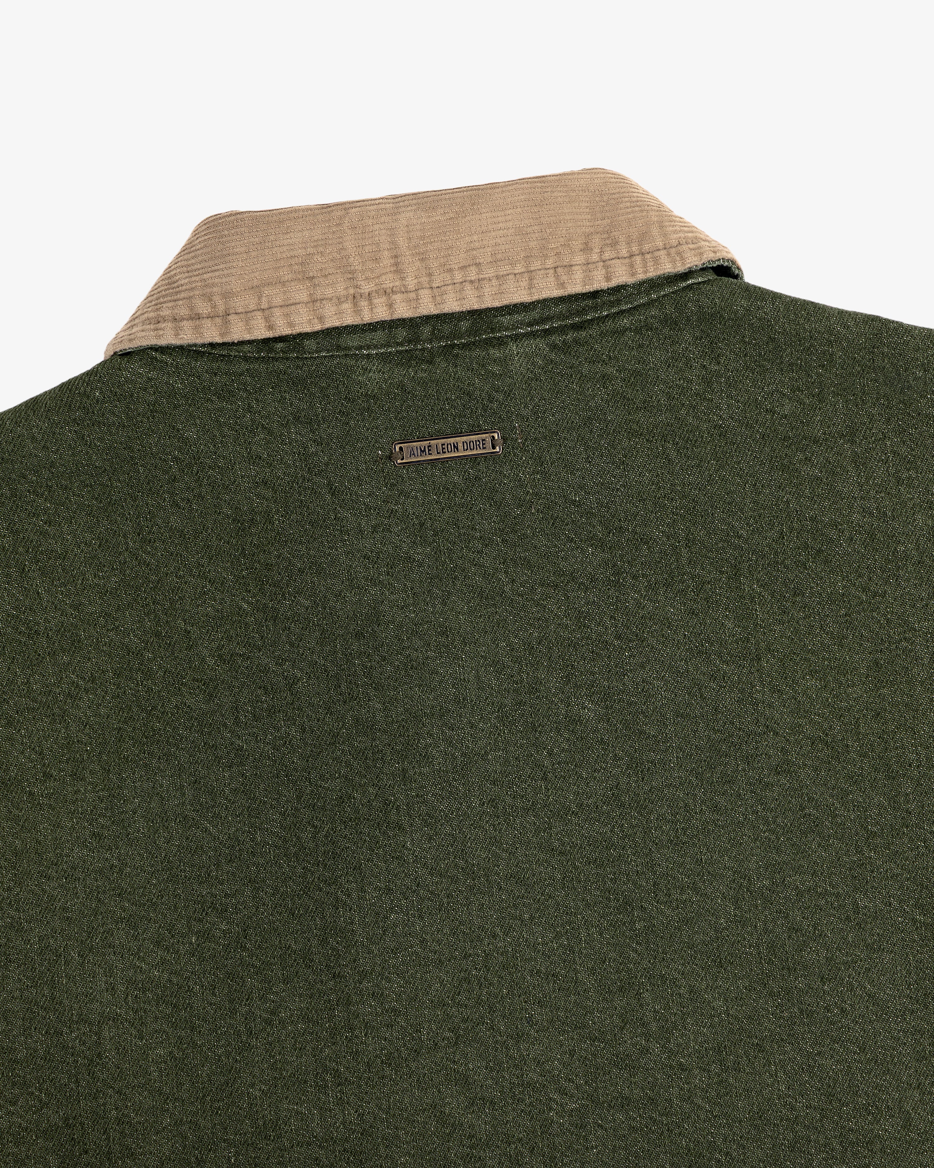 Close-up of the back of a green Denim Zip Jacket with a beige collar and a small metal Jamie Leake logo tag.