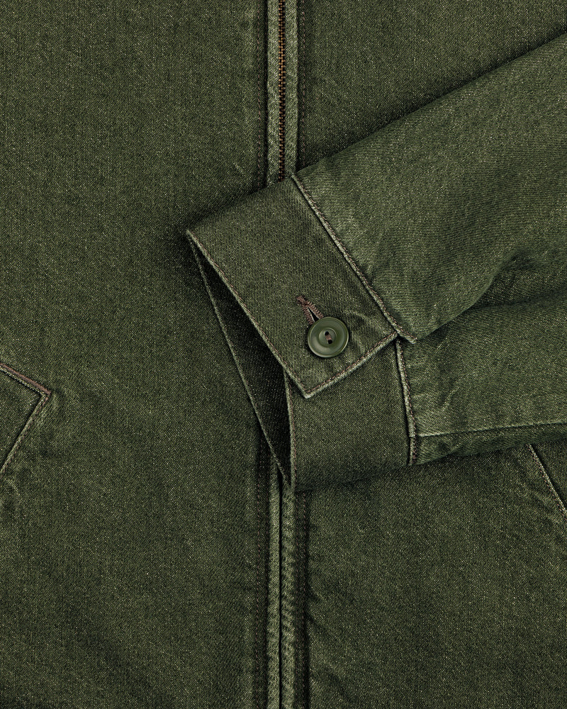 Close-up of a Denim Zip Jacket sleeve with a button cuff and seam details, resting on the jacket front.
