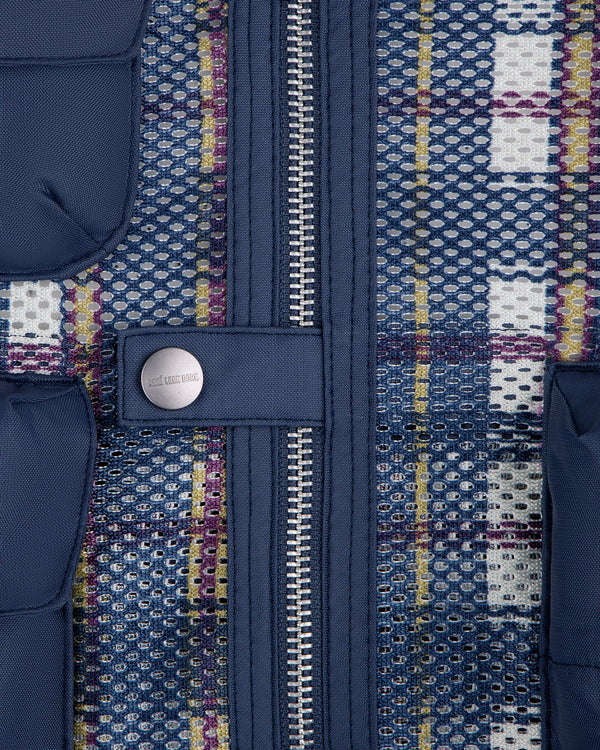Close-up of the Nylon Madras Utility Vest's blue mesh fabric, zipper, button, pockets, and multicolored threads.