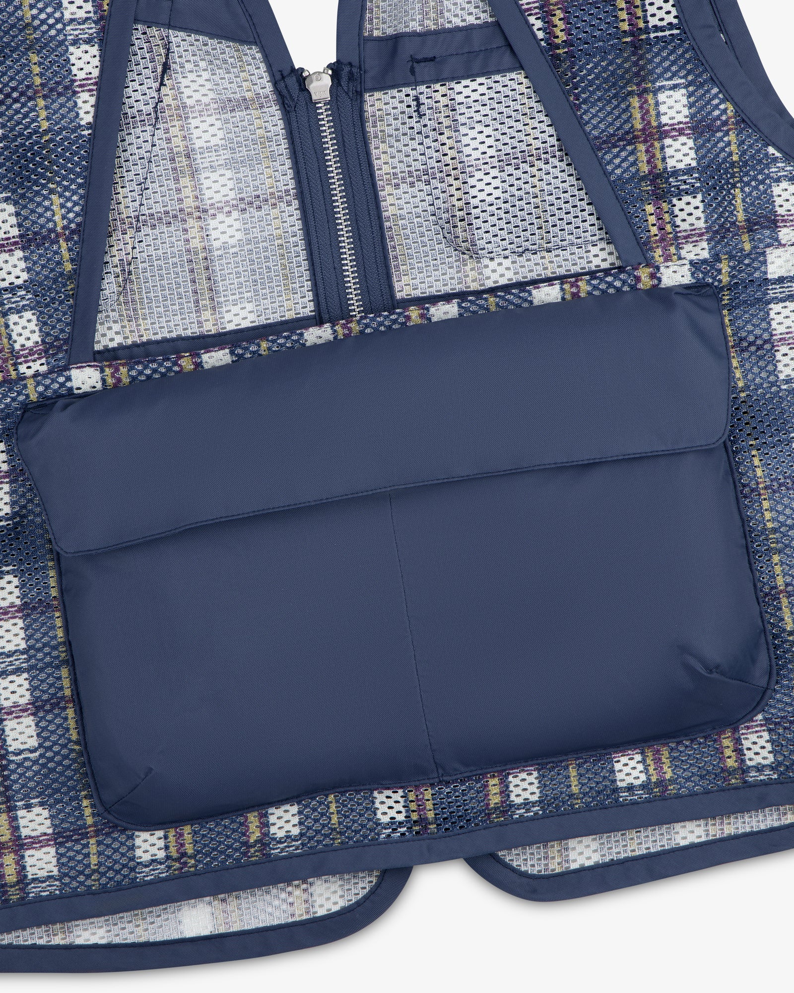 Close-up of the Nylon Madras Utility Vest in blue plaid mesh with a solid navy zippered back pocket.