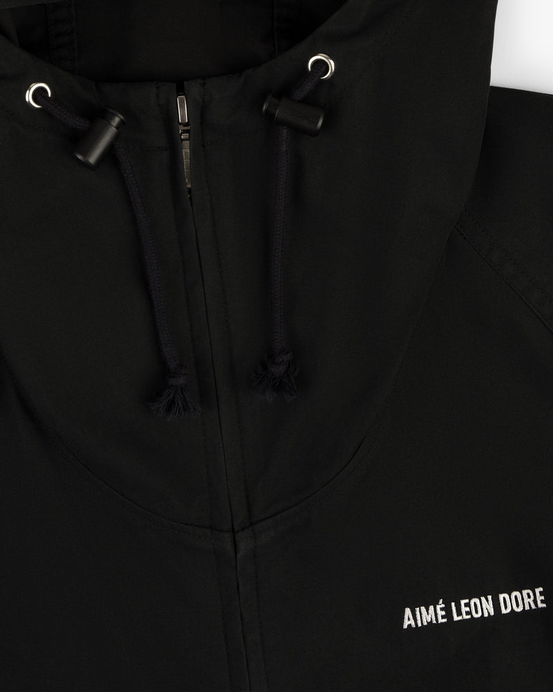 Close-up of the Micro Logo Lightweight Jacket, black with a zipper, drawstrings, and white chest embroidery.