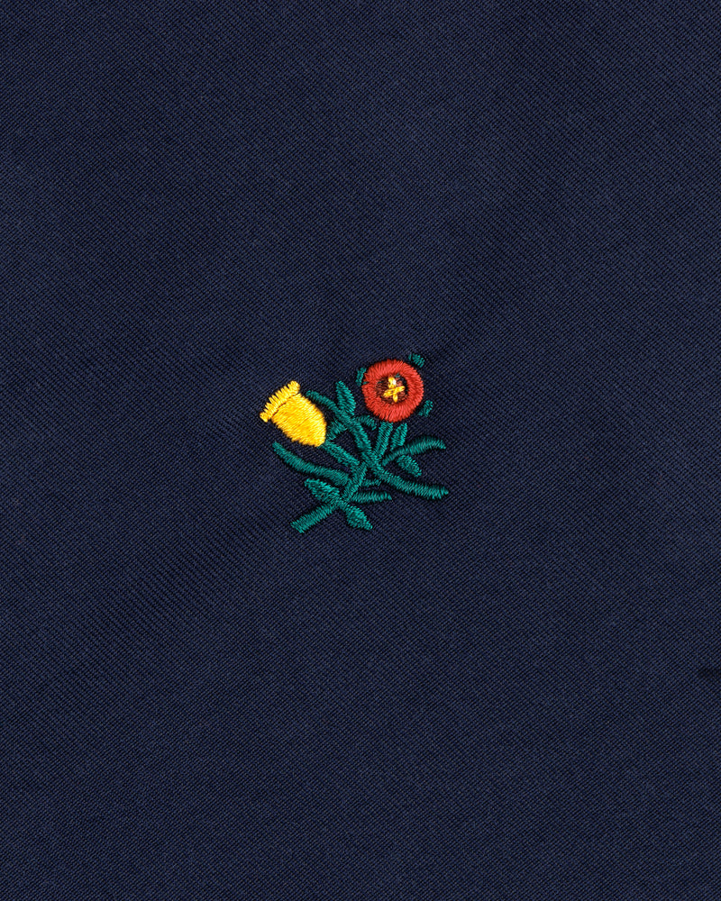Embroidered yellow and red flowers with green stems adorn the Crest Casual Jacket’s dark blue fabric.