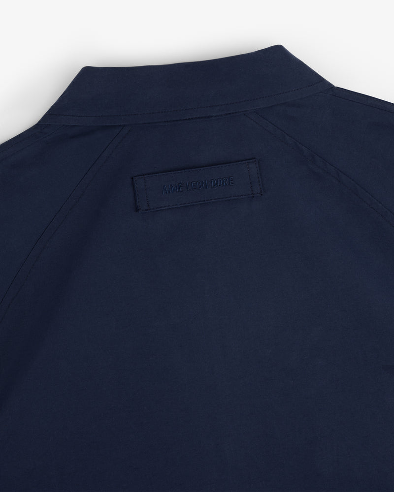 Close-up of the back of a navy Crest Casual Jacket featuring a stitched AIME LEON DORE label below the collar.