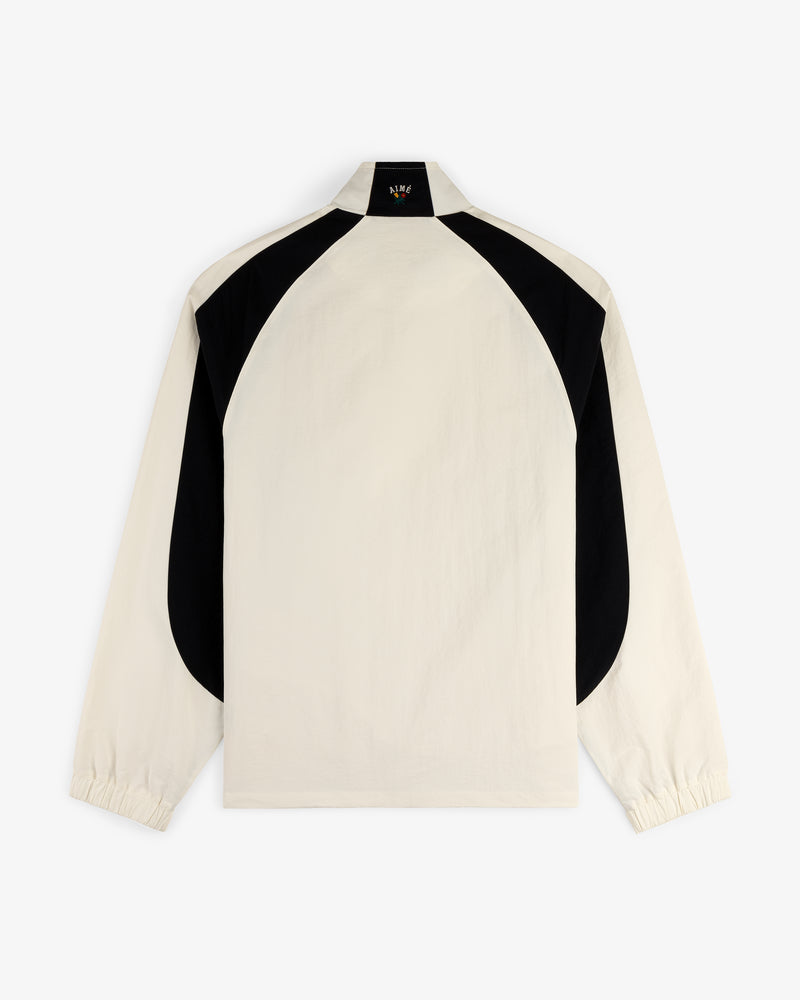 Back view of the Crest Nylon Half-Zip Pullover, cream with black curved panels on shoulders and sides.